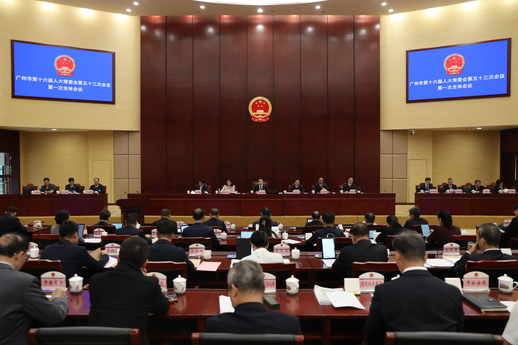 广州市人大常委会第五十三次会议第一次全体会议现场，会场屏幕显示会议名称